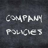 "Company Policies" written in white chalk lettering on a dark chalkboard