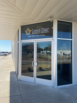 Glass double-door storefront entrance with Lone Star Candle Supply sign and 5800 Park Vista Circle address above